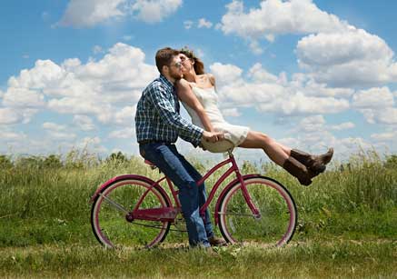 Ein Mann mit einer Frau auf der Fahrradlenkstange. Life Coaching Online. Online Coaching. Online Coach.