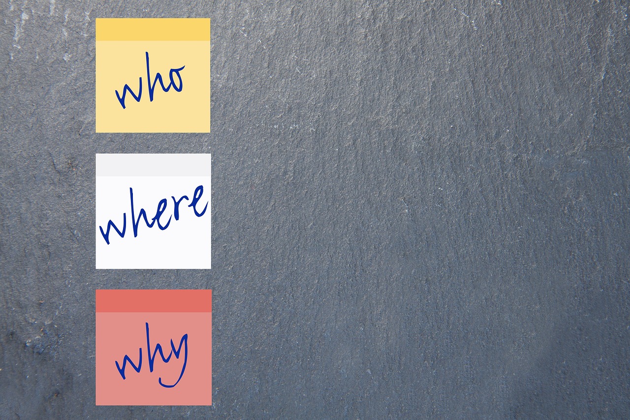 Three post-it notes with the words Who, Where, Why. The importance of agile coaches in today's business world.