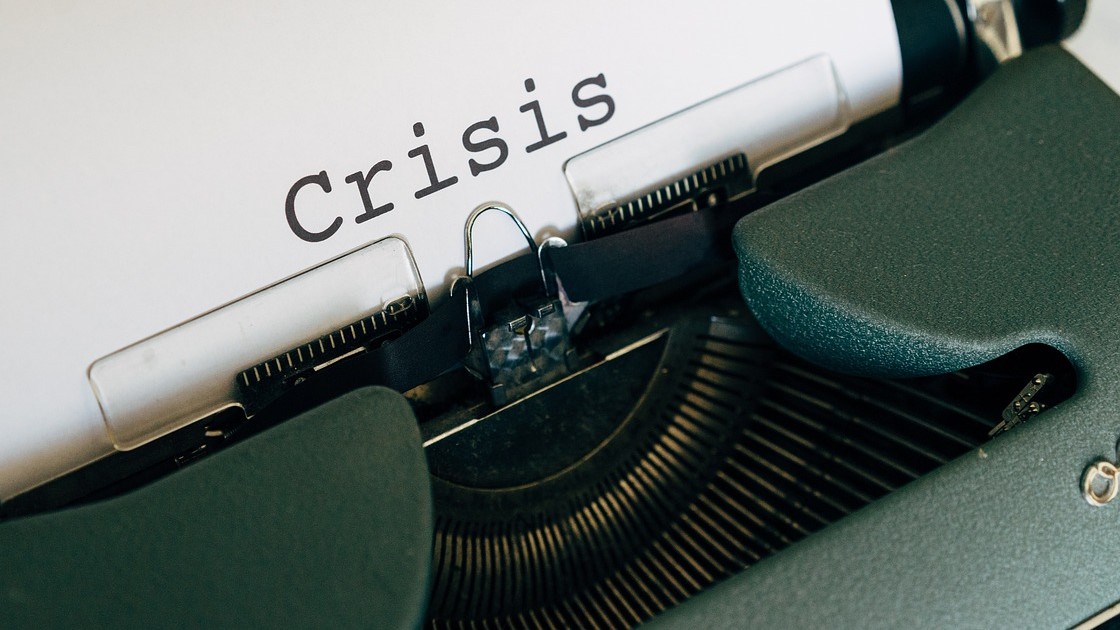 Schreibmaschine mit der Aufschrift "Crisis"
